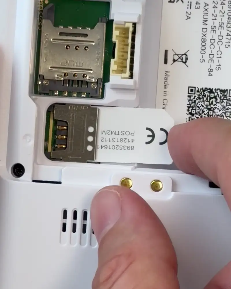 Inserting a standard SIM card into SIM slot 1 on the DX8000 and locking the holder